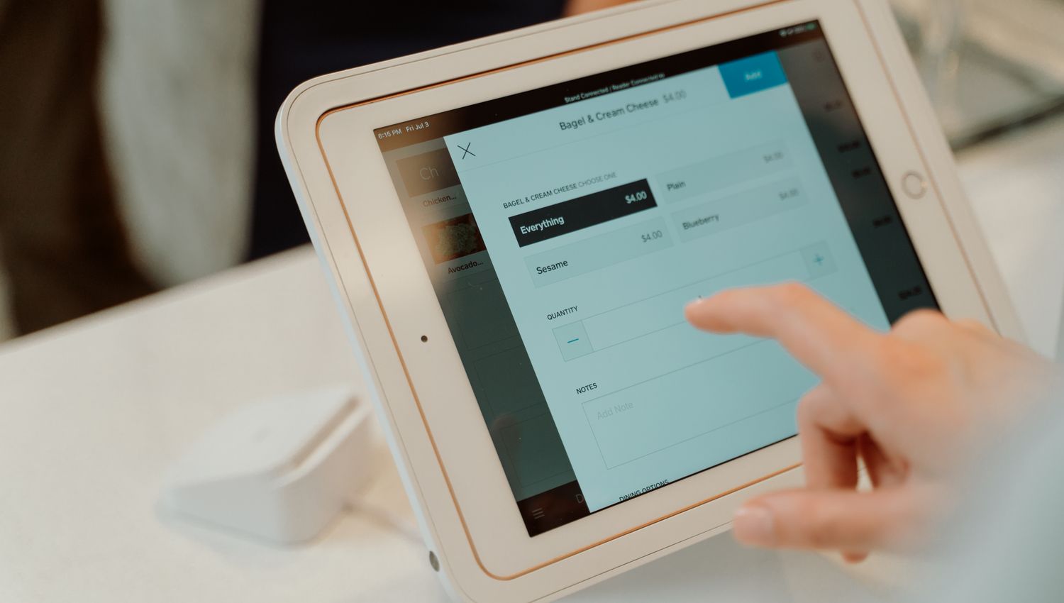スタンドに固定されたiPadを店舗のカウンターで操作している様子